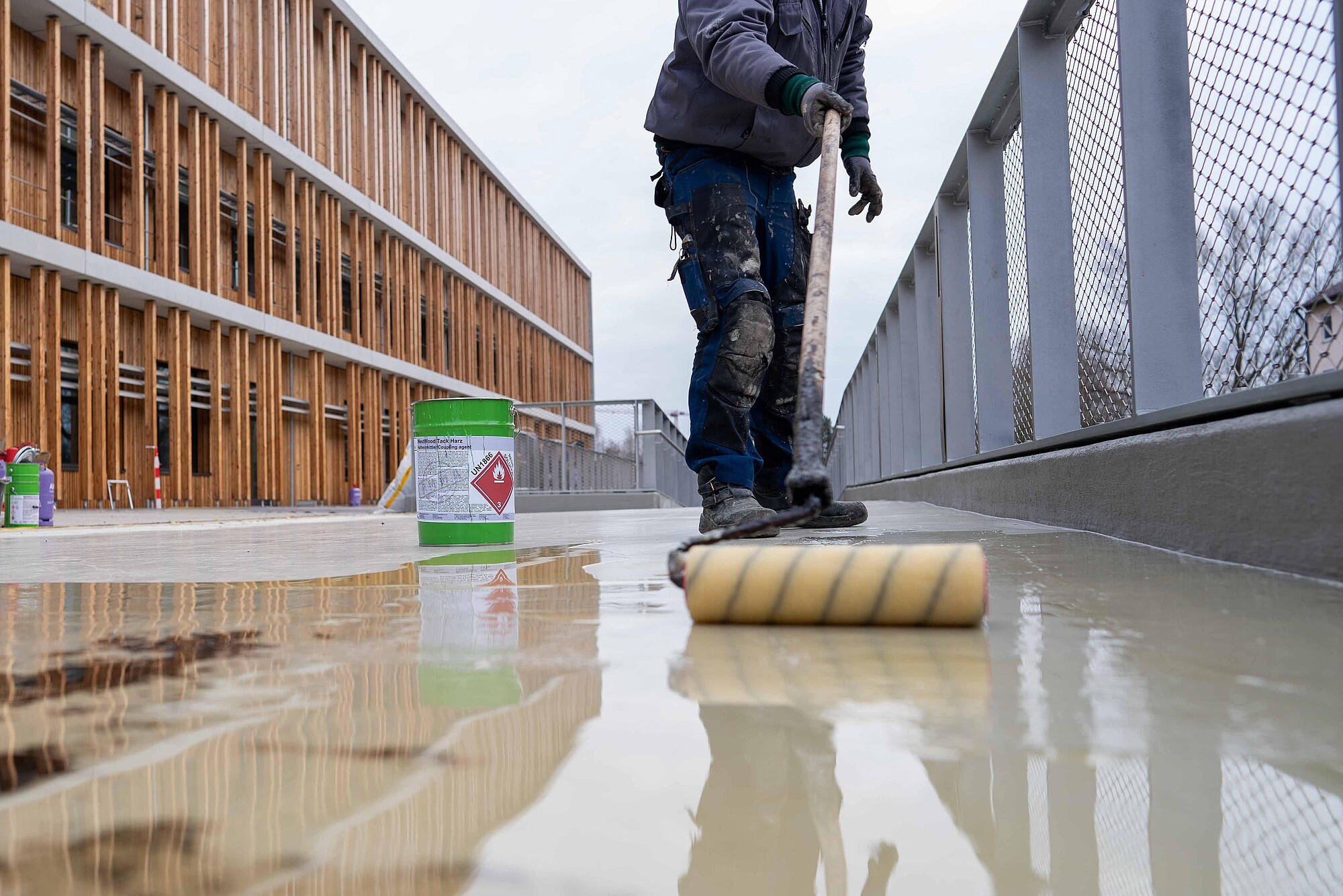 Fachverarbeiter appliziert Haftvermittler für nachfolgenden Asphalt.